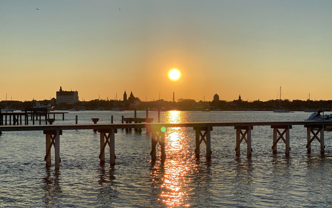 Sun setting over a dock and water in St. Augustine, Florida showcasing the importance of supporting local independent insurance agency